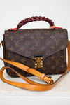 Designer handbag with monogram pattern on a white background