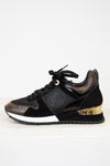 Black sneaker with gold accents on a white background