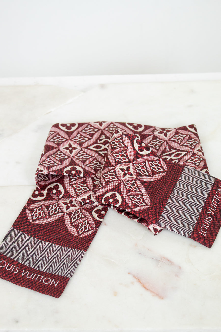 Louis Vuitton scarf with intricate pattern on a marble surface