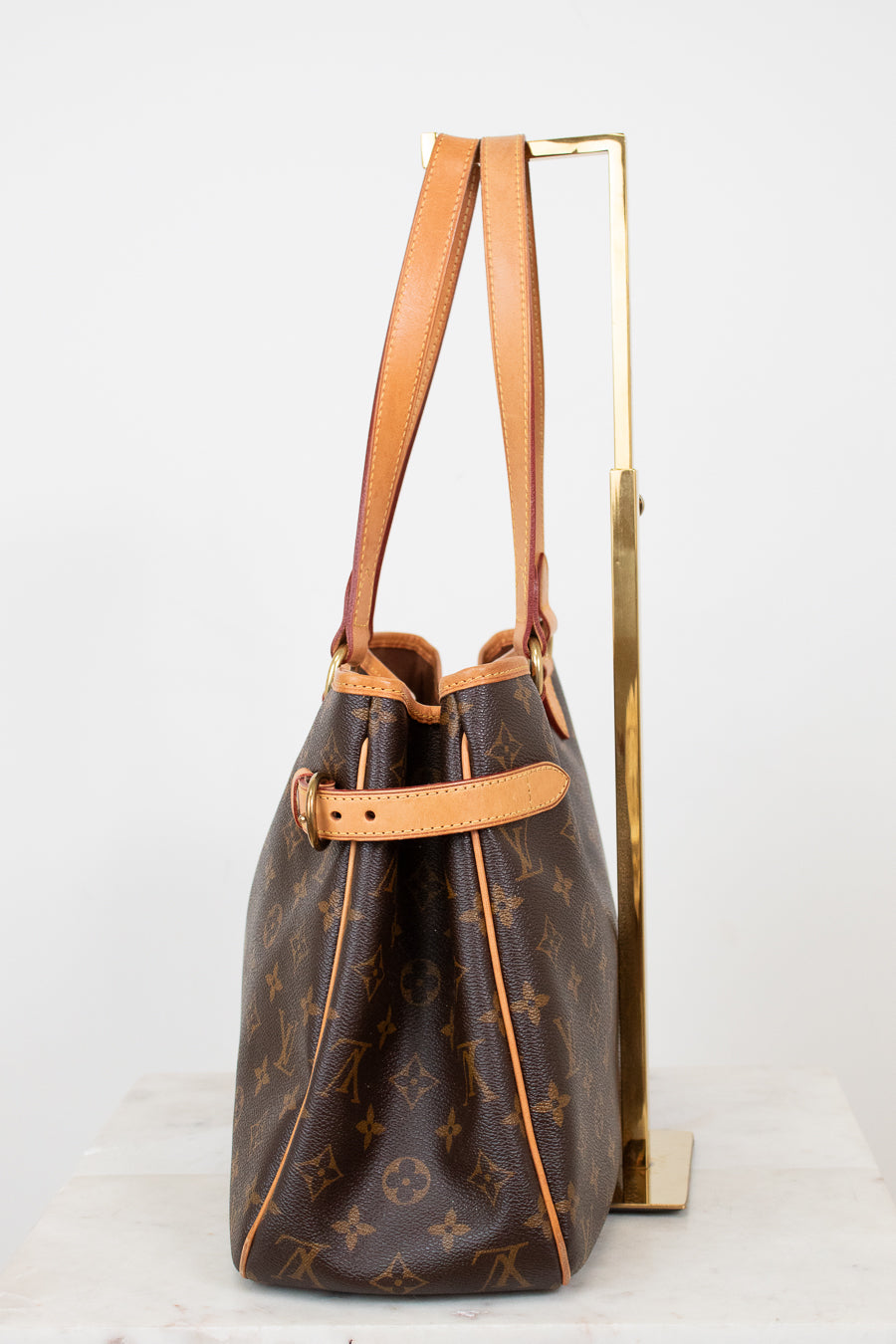 Brown monogram handbag with tan handles on a white background