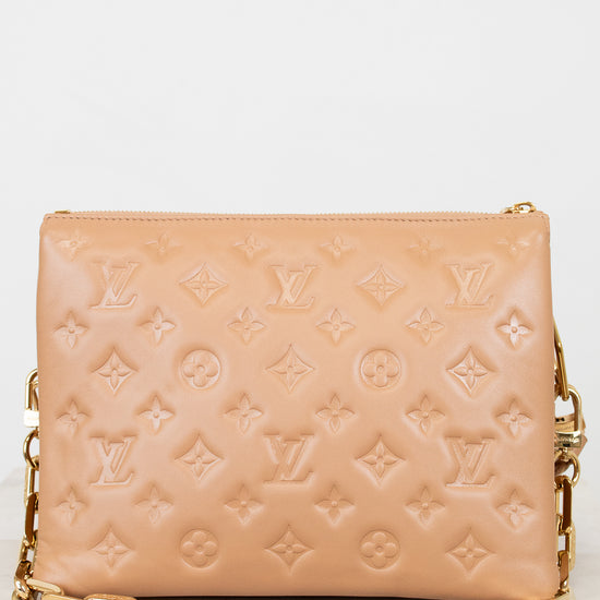 Beige handbag with gold chain strap on a white background