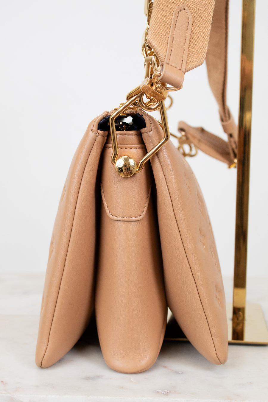 Beige handbag with gold clasp on a white background