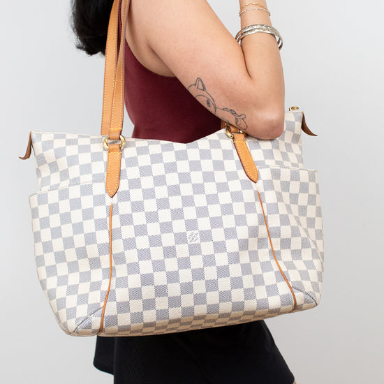 Person holding a checkered handbag with a plain background