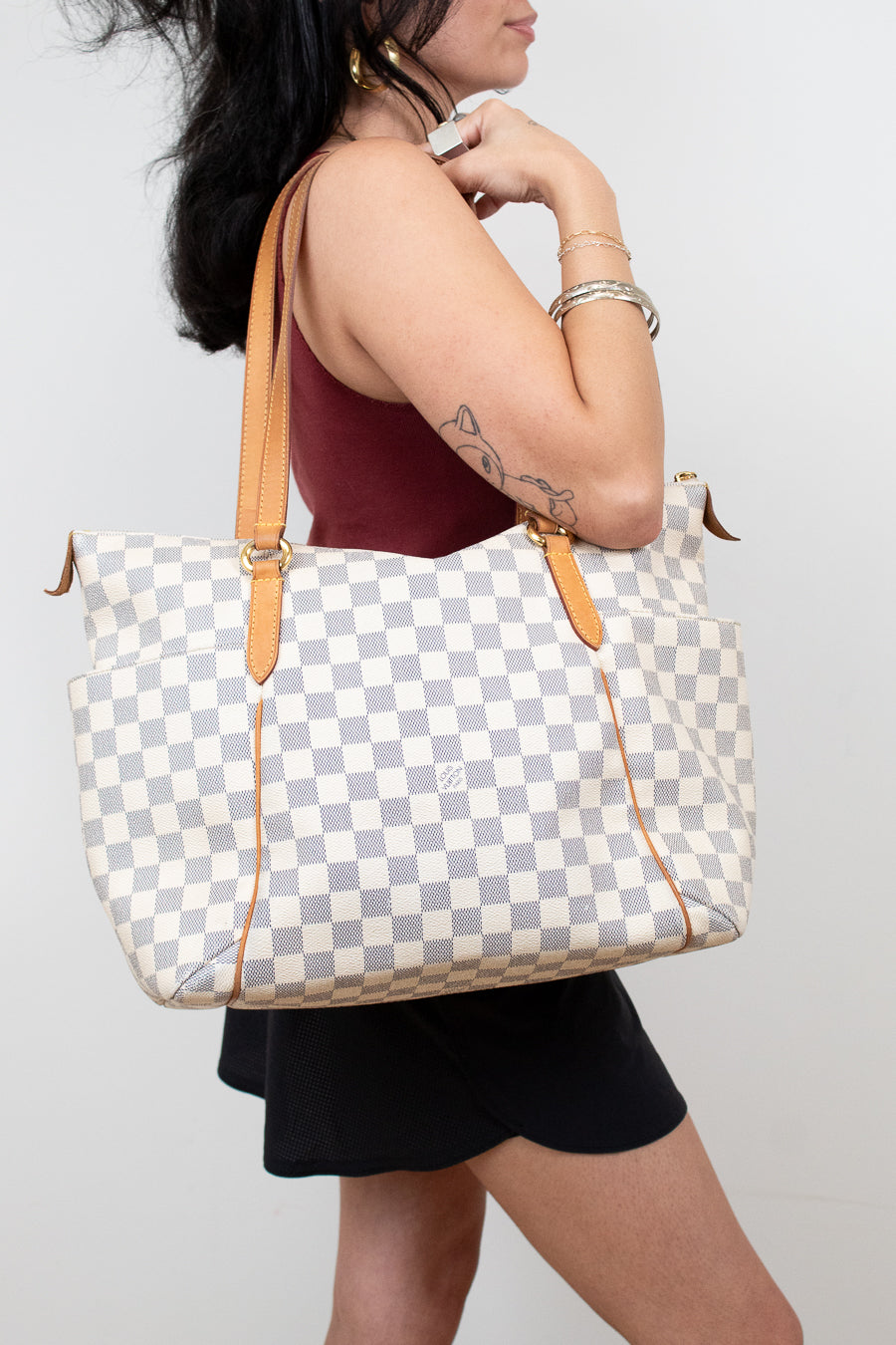Person holding a checkered handbag with a plain background