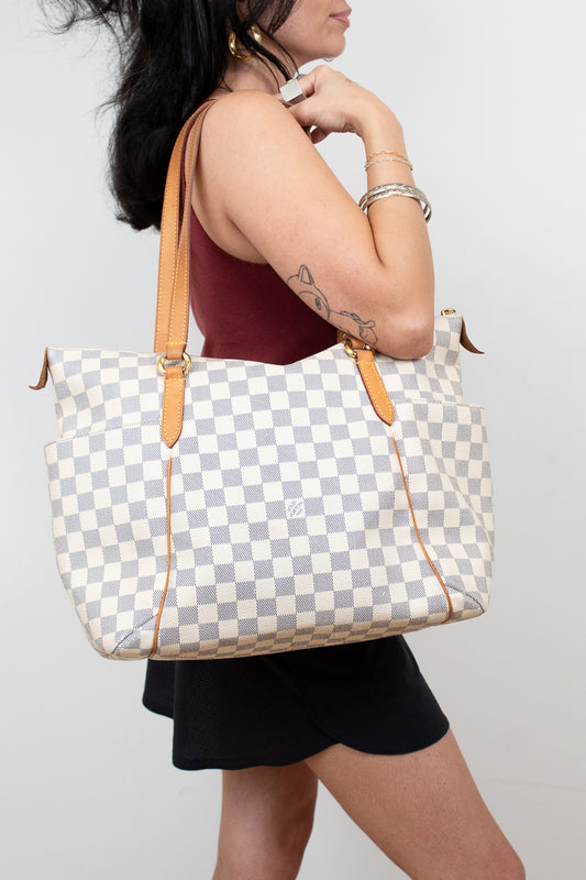 Person holding a checkered handbag with a plain background
