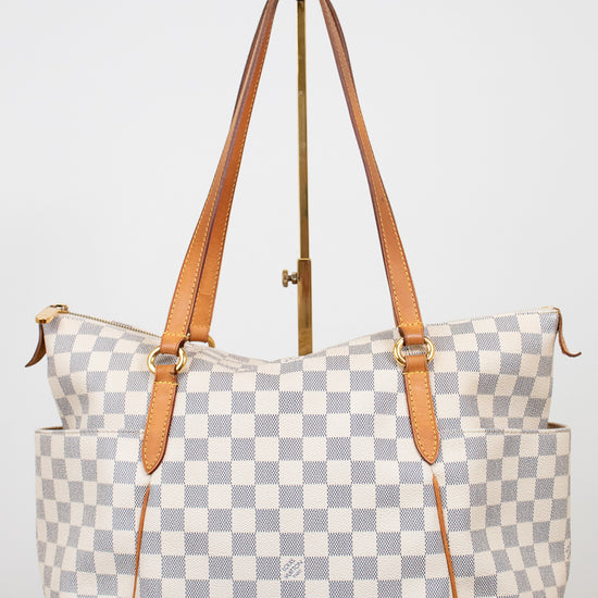 Checkered handbag with brown straps on a white background
