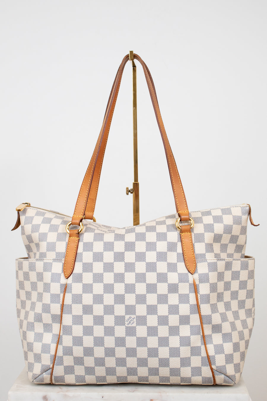 Checkered handbag with brown straps on a white background