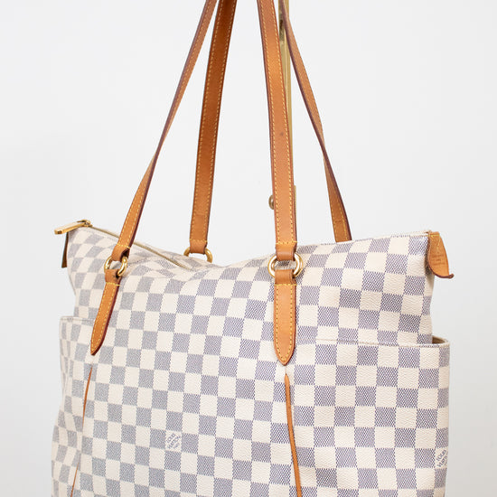 Checkered handbag with brown straps on a white background