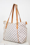 Checkered handbag with brown straps on a white background