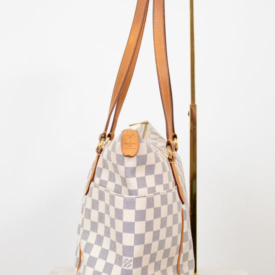 Checkered bag with brown straps on a white background