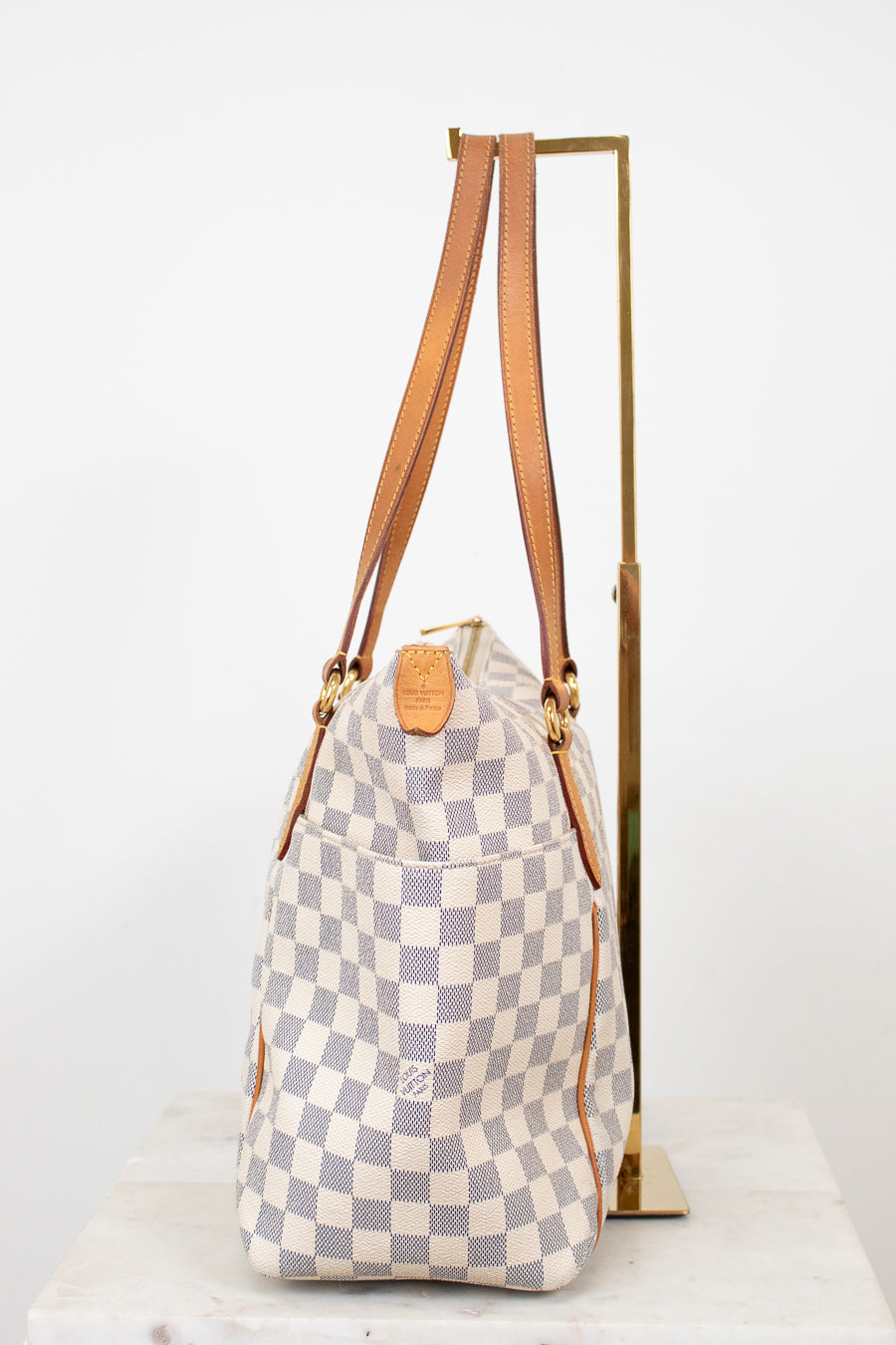 Checkered bag with brown straps on a white background