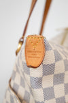 Louis Vuitton handbag with checkered pattern and brown leather tag.