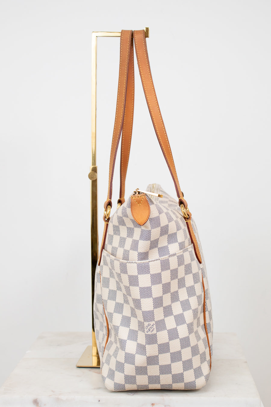 Checkered handbag with brown straps on a white background