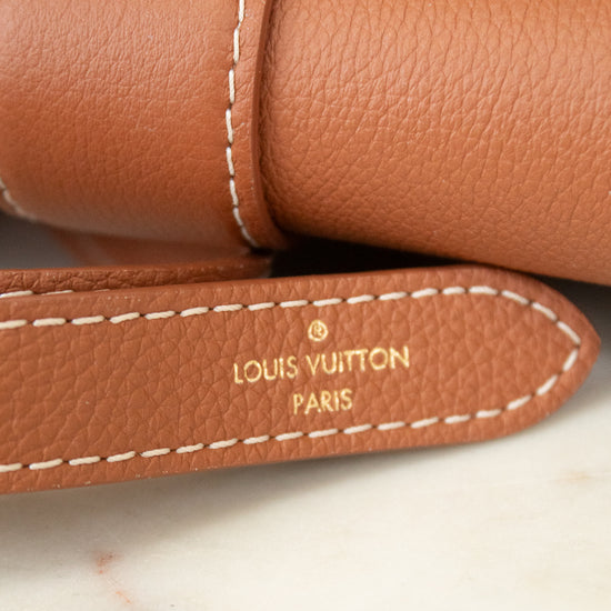 Close-up of a Louis Vuitton brown leather product with visible branding.