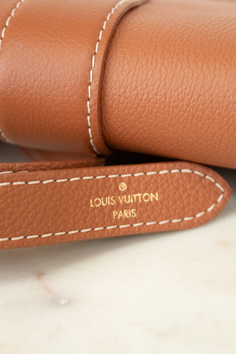 Close-up of a Louis Vuitton brown leather product with visible branding.
