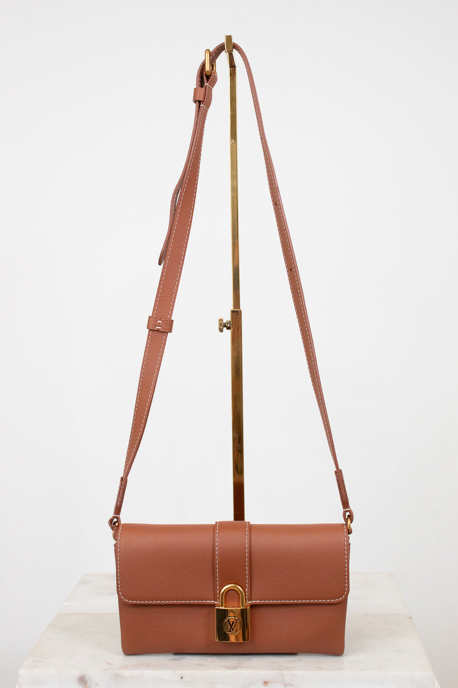 Brown leather handbag with a strap on a white background