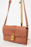Brown leather handbag with gold lock on a white background