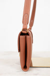 Brown leather handbag with a strap on a white background
