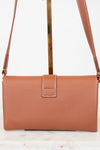 Brown leather handbag with a strap on a white background