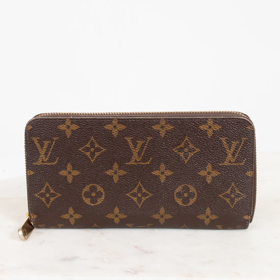 Brown wallet with monogram pattern on a white background