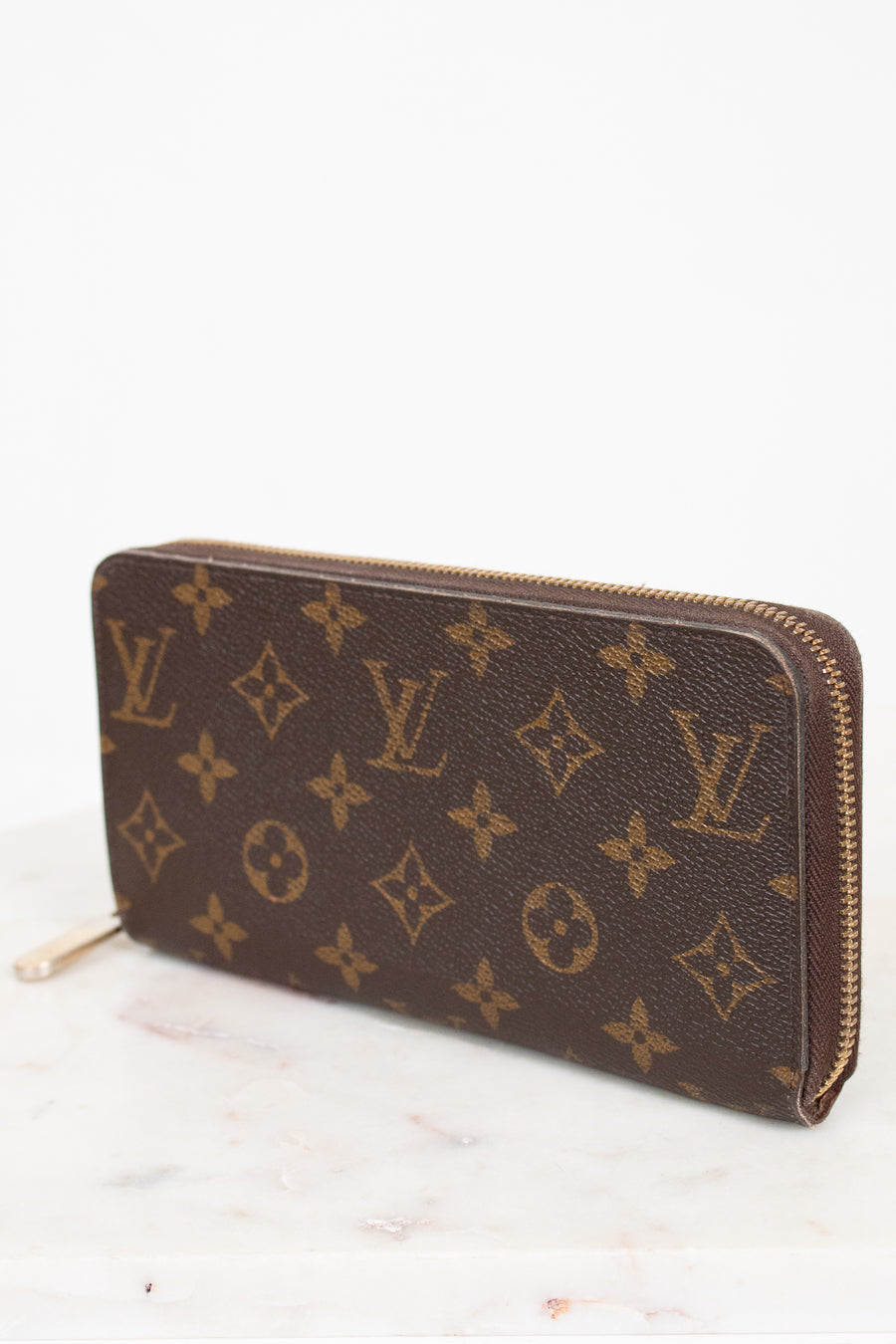 Louis Vuitton wallet with monogram pattern on a white background