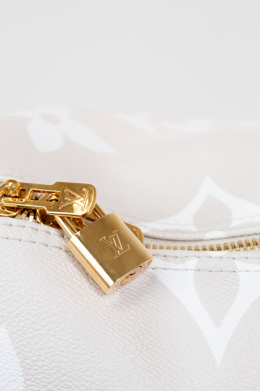 Gold padlock with a visible brand logo on a white textured background