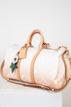 Designer handbag with beige strap and white body on a light background
