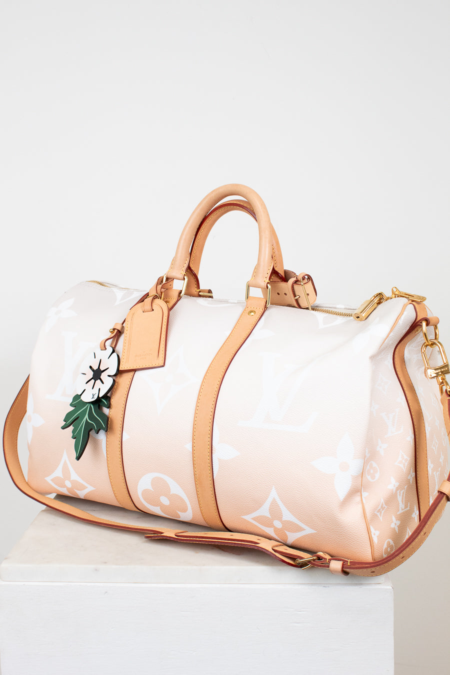Designer handbag with beige strap and white body on a light background