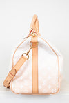 Designer handbag with beige strap and white monogram pattern on a light gray background