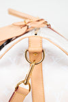 Close-up of a beige handbag with gold hardware on a white background