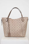 Beige handbag with monogram pattern on a white background