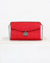 Red handbag with a silver chain on a white background