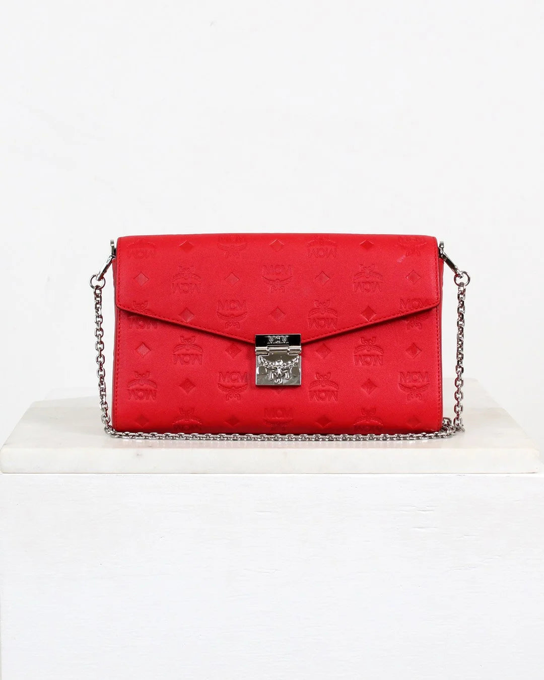 Red handbag with a silver chain on a white background