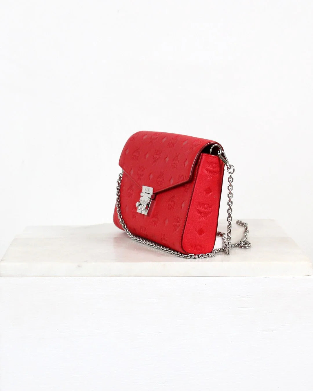 Red handbag with a chain strap on a white background
