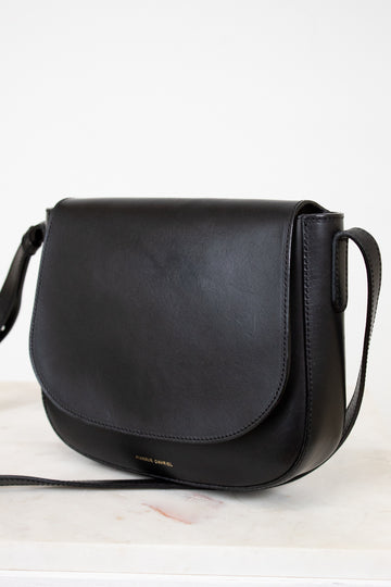 Black leather handbag on a light background