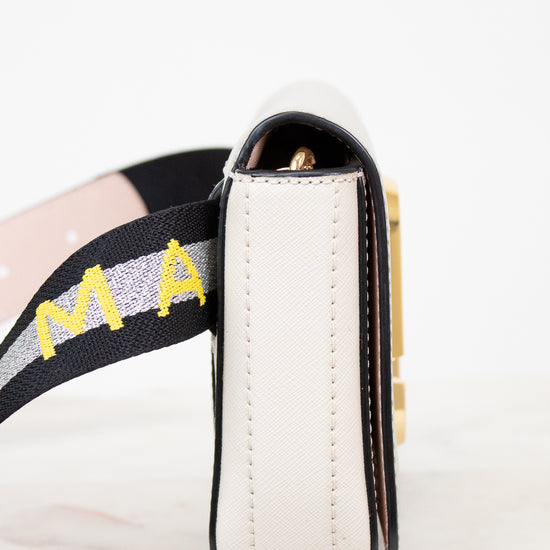 Close-up of a side of bag with 'Marc Jacobs' on the strap against a white background