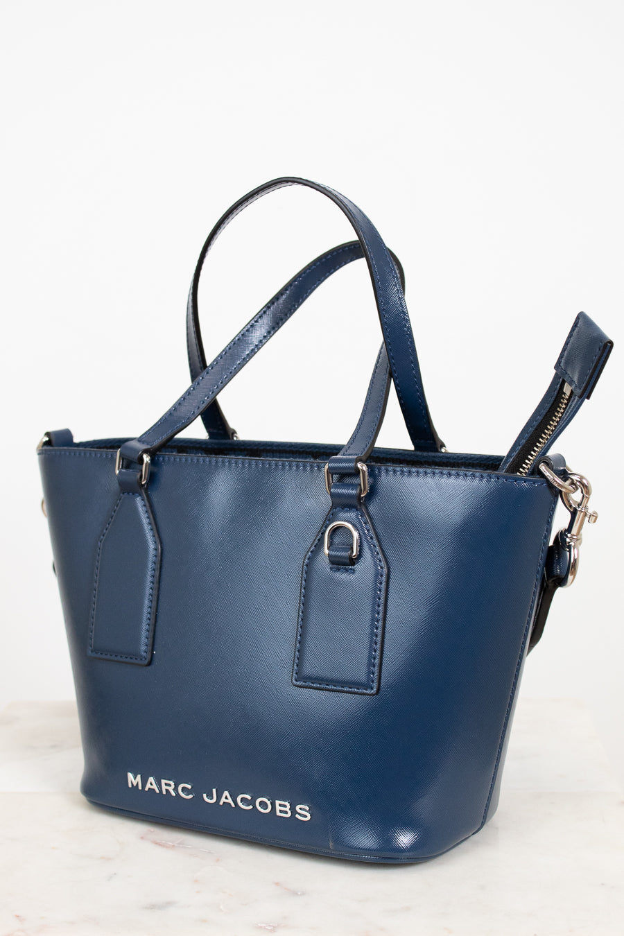 Blue handbag with 'Marc Jacobs' branding on a light background