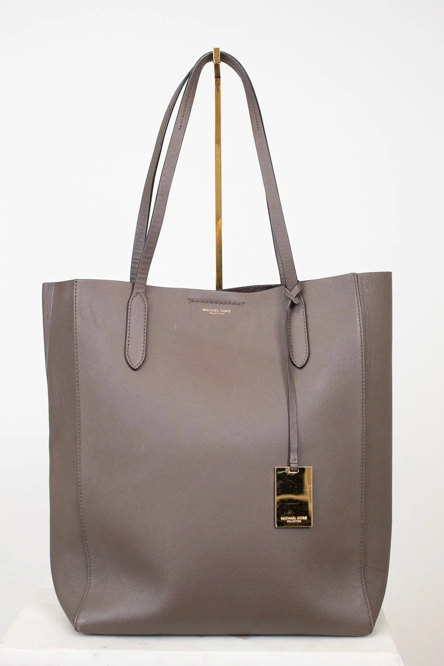 Gray tote bag with a gold clasp on a white background