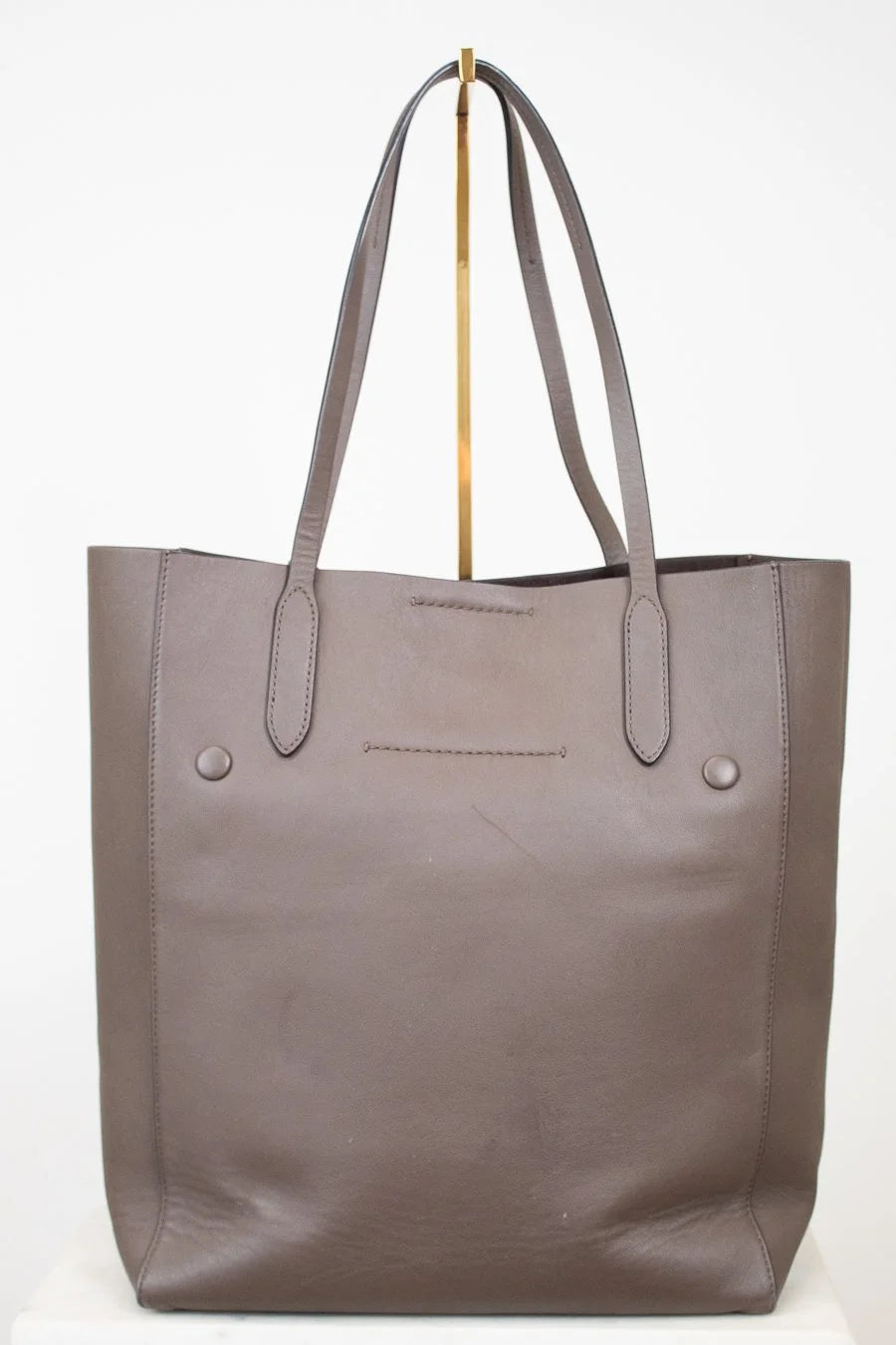 Brown tote bag with gold accents on a white background