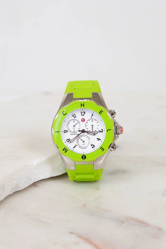 Green watch with a white face on a marble surface