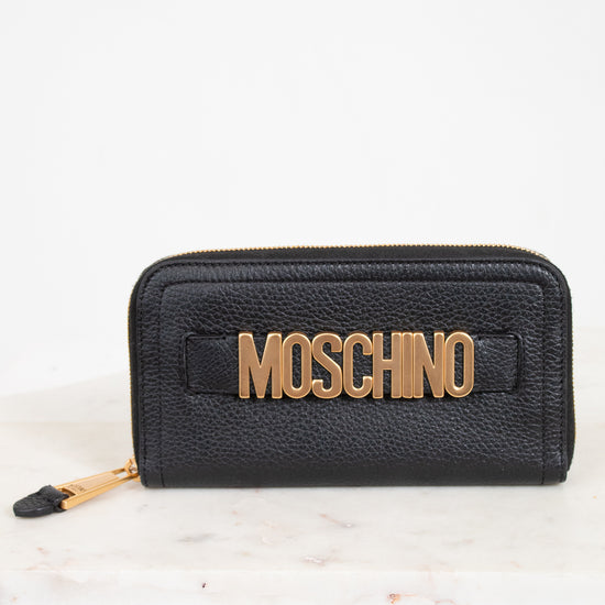 Black wallet with gold 'Moschino' logo on a white background