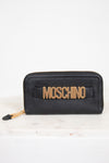 Black wallet with gold 'Moschino' logo on a white background
