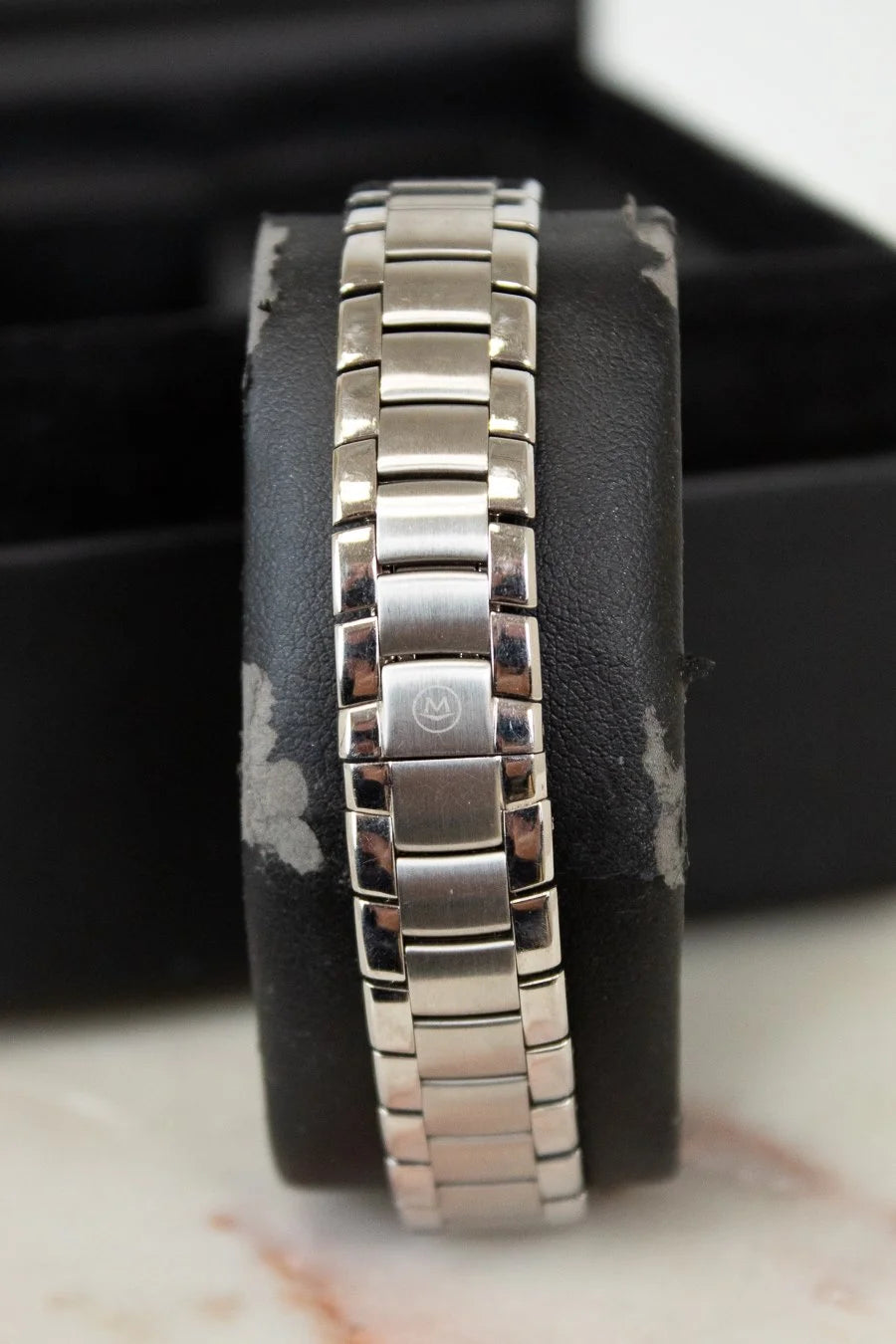 Silver bracelet on a black cushion with a blurred background