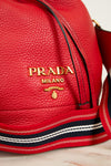 Red Prada handbag with gold logo on a light background