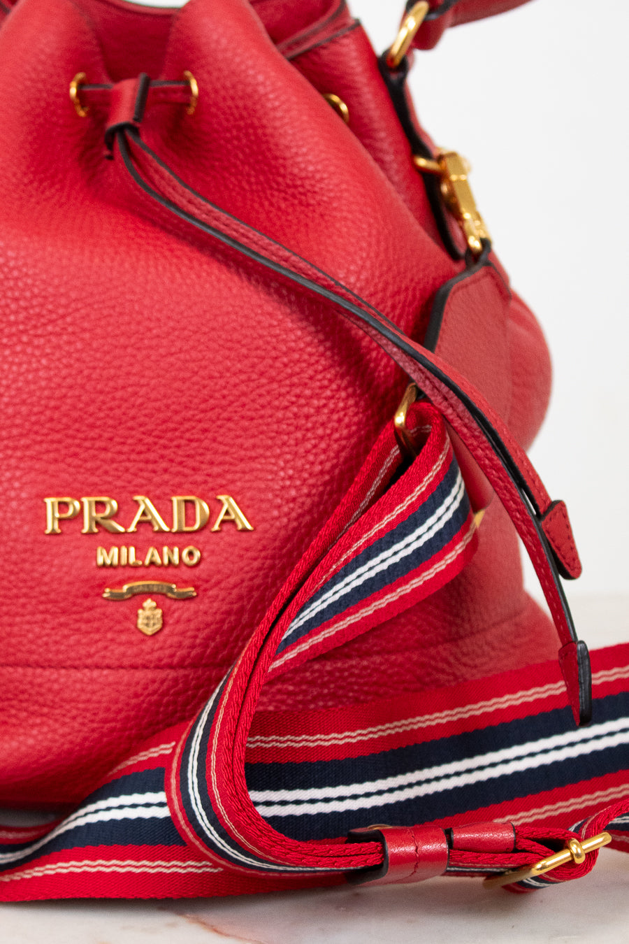 Red Prada handbag with gold logo on a light background
