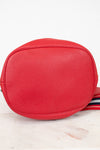 Red textured crossbody bag with a striped strap on a light background