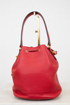 Red leather handbag with gold accents on a light gray background