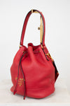Red leather handbag with gold accents on a white background