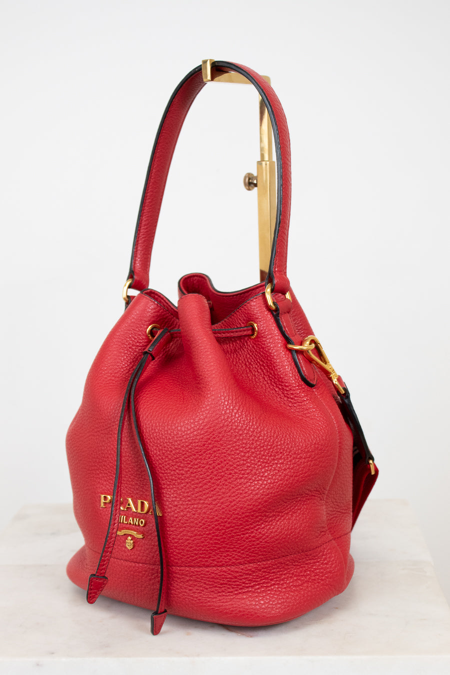 Red leather handbag with gold accents on a white background