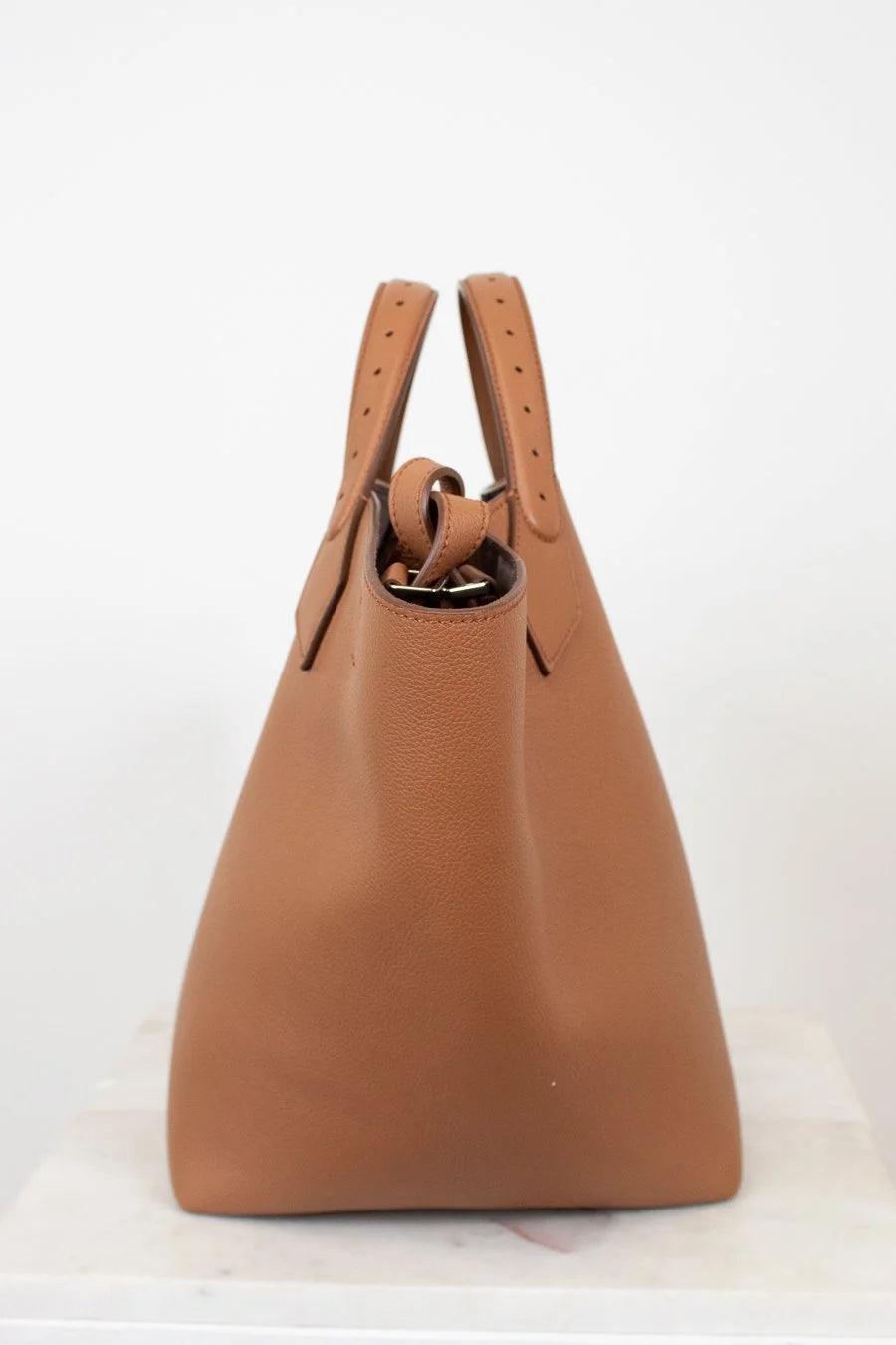 Brown leather handbag with handles on a white background